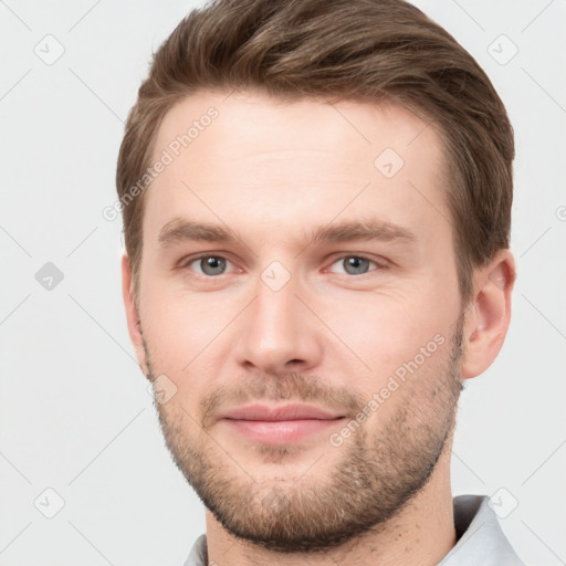 Joyful white young-adult male with short  brown hair and grey eyes