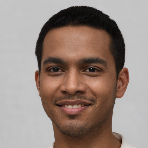 Joyful black young-adult male with short  black hair and brown eyes