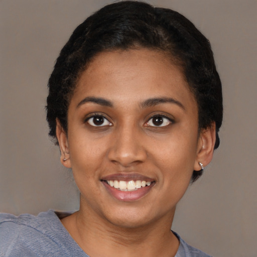 Joyful black young-adult female with short  black hair and brown eyes