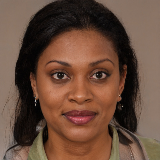Joyful latino adult female with medium  brown hair and brown eyes