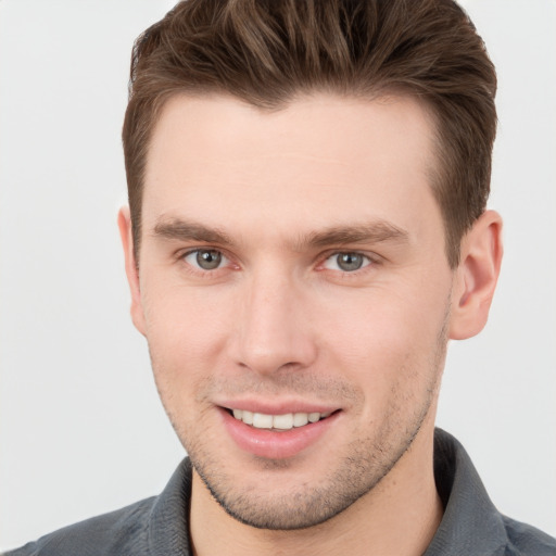 Joyful white young-adult male with short  brown hair and grey eyes