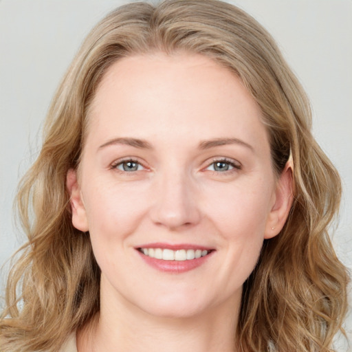 Joyful white young-adult female with long  brown hair and blue eyes