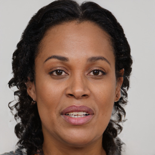 Joyful black adult female with long  brown hair and brown eyes