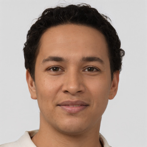 Joyful latino young-adult male with short  brown hair and brown eyes