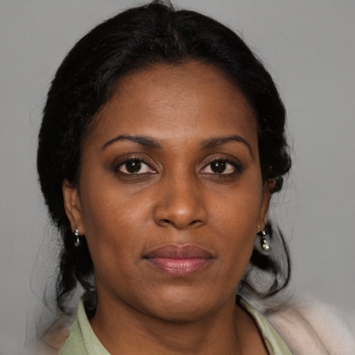 Joyful black young-adult female with medium  brown hair and brown eyes