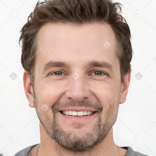 Joyful white adult male with short  brown hair and grey eyes