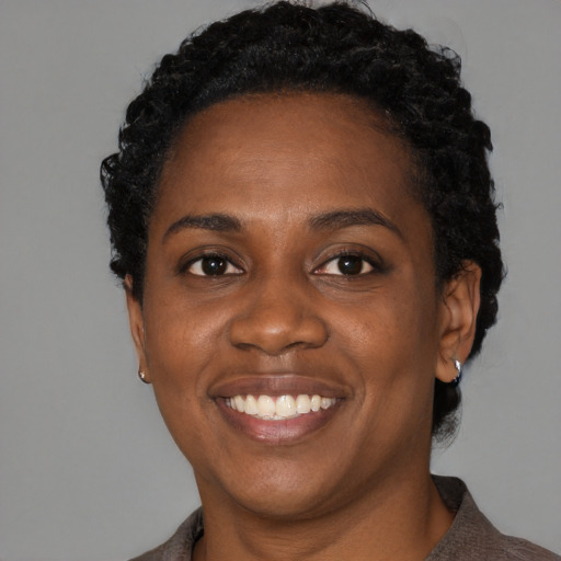 Joyful black adult female with short  black hair and brown eyes