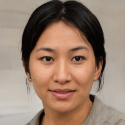 Joyful asian young-adult female with medium  brown hair and brown eyes