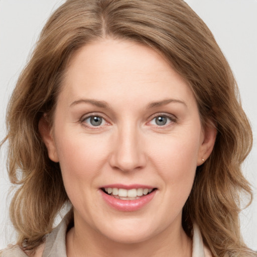 Joyful white adult female with medium  brown hair and blue eyes