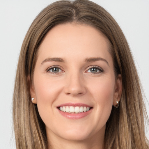 Joyful white young-adult female with long  brown hair and grey eyes