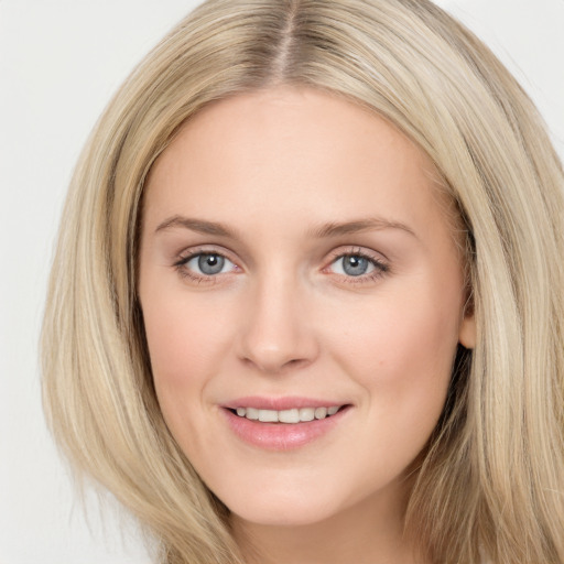 Joyful white young-adult female with long  brown hair and blue eyes