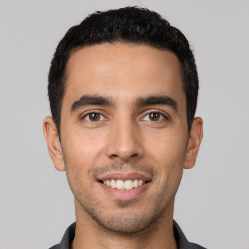 Joyful white young-adult male with short  black hair and brown eyes