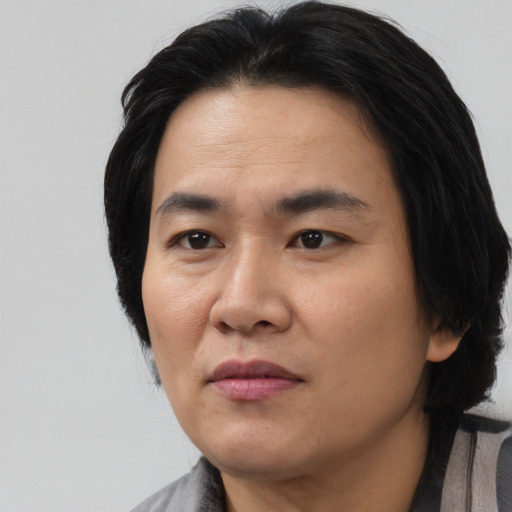 Joyful asian adult male with medium  black hair and brown eyes