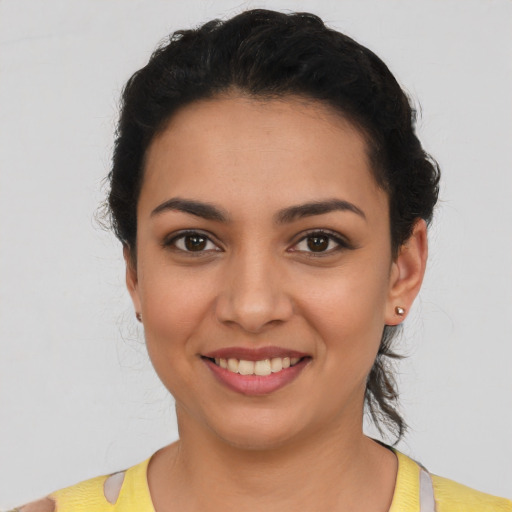 Joyful latino young-adult female with short  black hair and brown eyes