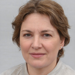 Joyful white adult female with medium  brown hair and blue eyes