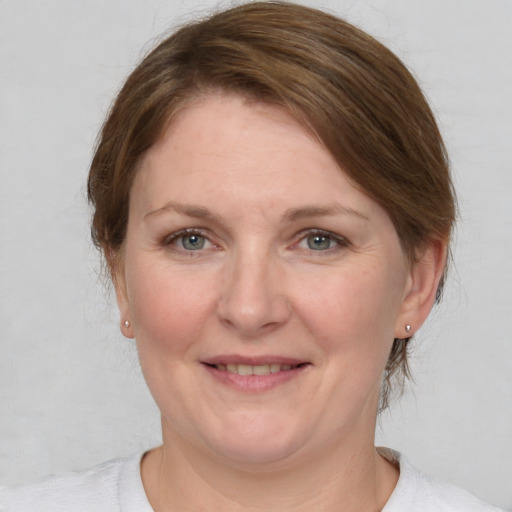 Joyful white adult female with medium  brown hair and grey eyes