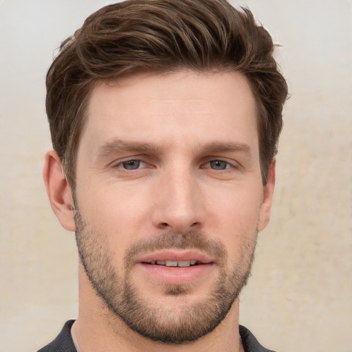 Joyful white young-adult male with short  brown hair and grey eyes