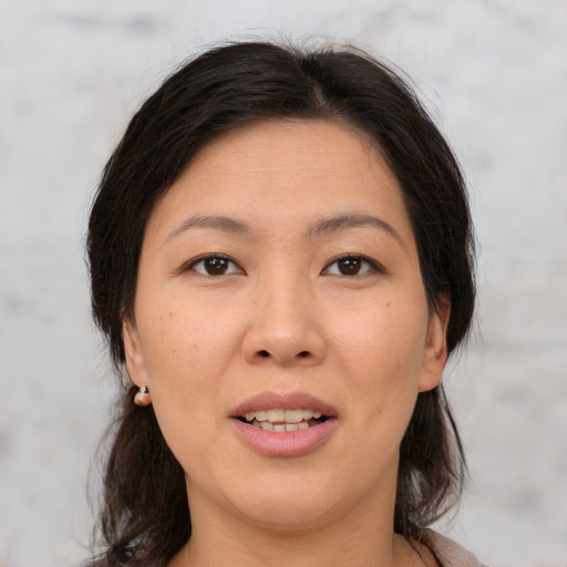 Joyful asian adult female with medium  brown hair and brown eyes