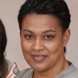 Joyful latino adult female with medium  brown hair and brown eyes