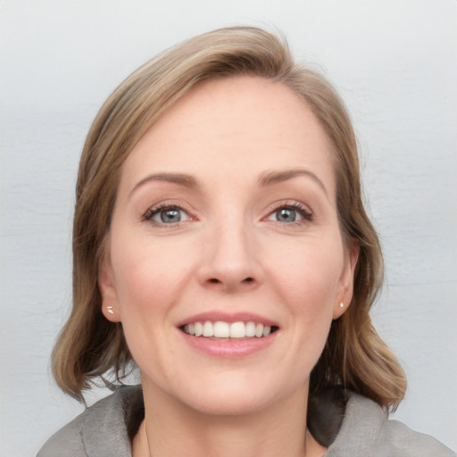 Joyful white young-adult female with medium  brown hair and blue eyes