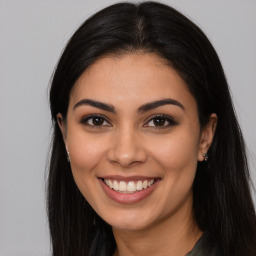 Joyful latino young-adult female with long  brown hair and brown eyes