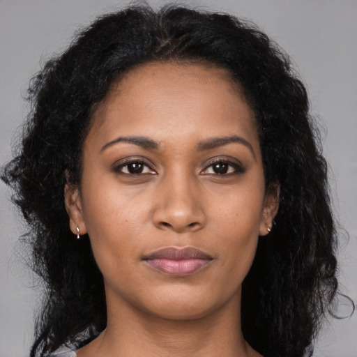 Joyful black young-adult female with long  black hair and brown eyes