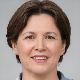 Joyful white adult female with medium  brown hair and grey eyes