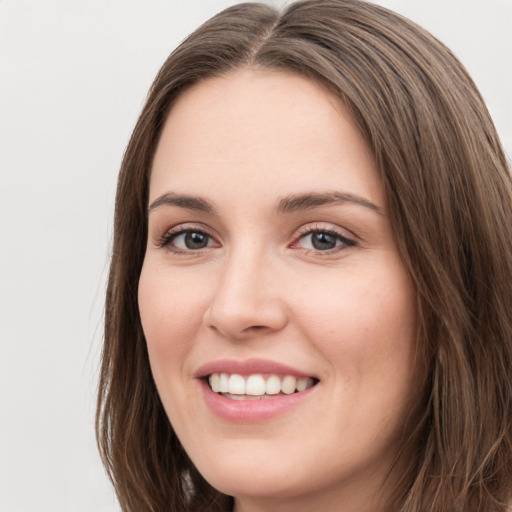 Joyful white young-adult female with long  brown hair and green eyes