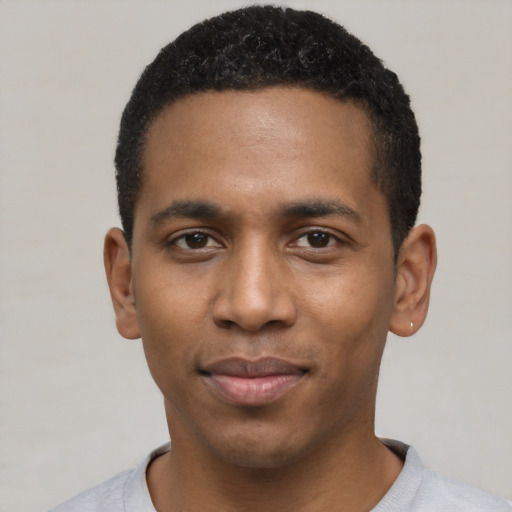 Joyful black young-adult male with short  black hair and brown eyes