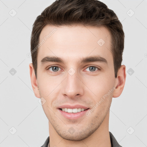 Joyful white young-adult male with short  brown hair and grey eyes