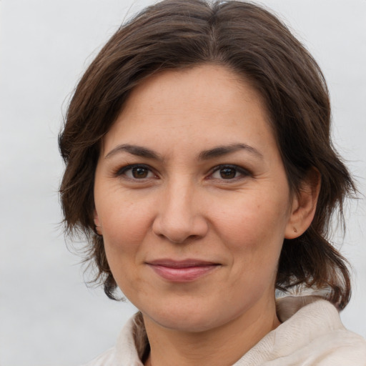Joyful white adult female with medium  brown hair and brown eyes