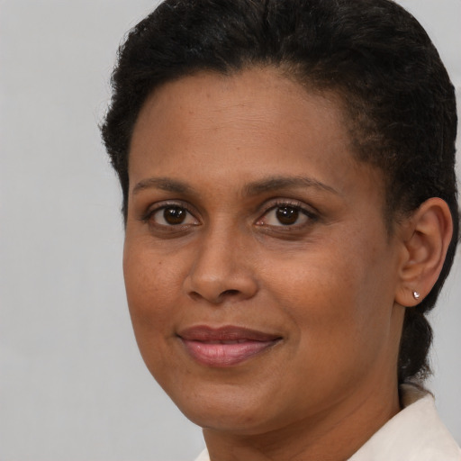 Joyful black adult female with short  brown hair and brown eyes