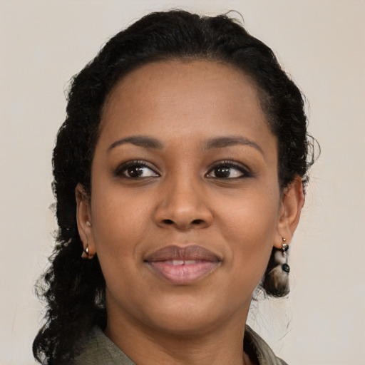 Joyful black young-adult female with long  black hair and brown eyes