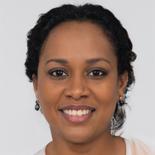 Joyful black young-adult female with short  black hair and brown eyes