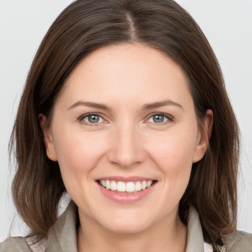 Joyful white young-adult female with medium  brown hair and grey eyes