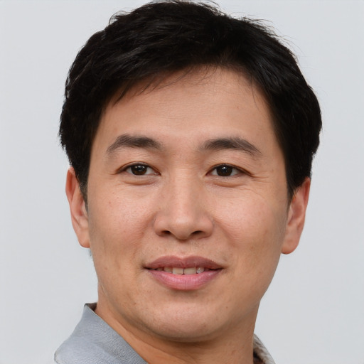 Joyful asian adult male with short  brown hair and brown eyes