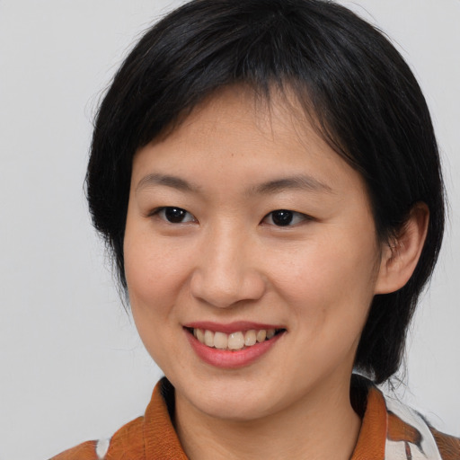 Joyful asian young-adult female with medium  brown hair and brown eyes
