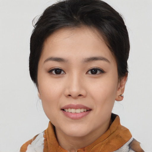 Joyful asian young-adult female with short  brown hair and brown eyes