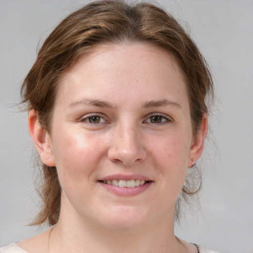 Joyful white young-adult female with medium  brown hair and blue eyes