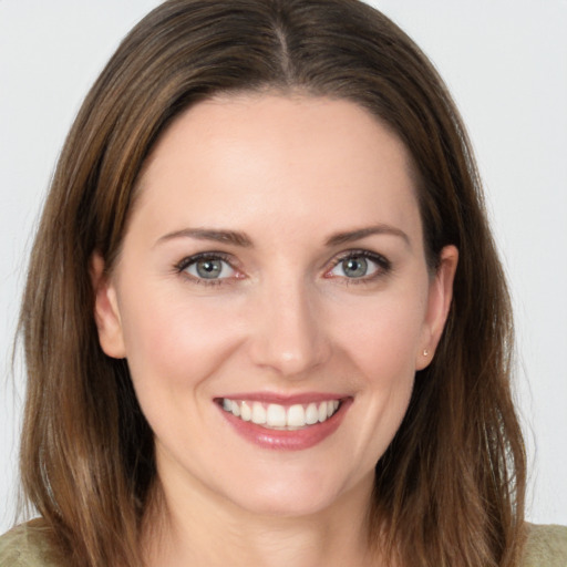 Joyful white young-adult female with long  brown hair and grey eyes