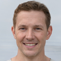 Joyful white adult male with short  brown hair and grey eyes