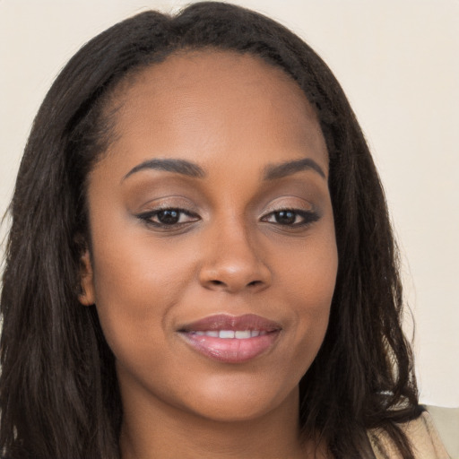 Joyful black young-adult female with long  brown hair and brown eyes