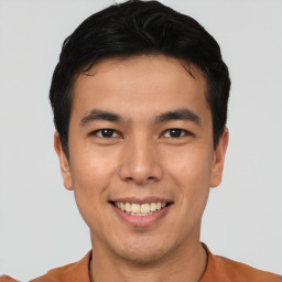 Joyful asian young-adult male with short  brown hair and brown eyes