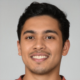 Joyful latino young-adult male with short  black hair and brown eyes