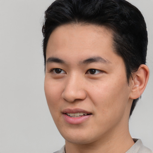 Joyful asian young-adult male with short  brown hair and brown eyes