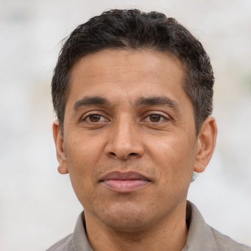 Joyful latino adult male with short  brown hair and brown eyes