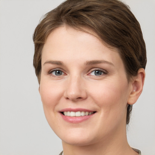 Joyful white young-adult female with short  brown hair and grey eyes