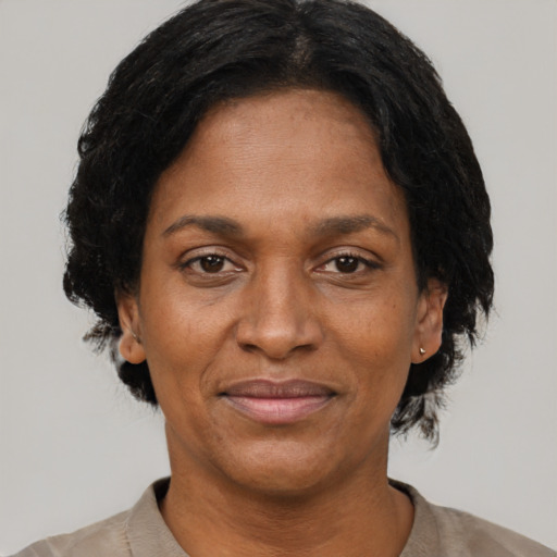 Joyful black adult female with short  black hair and brown eyes