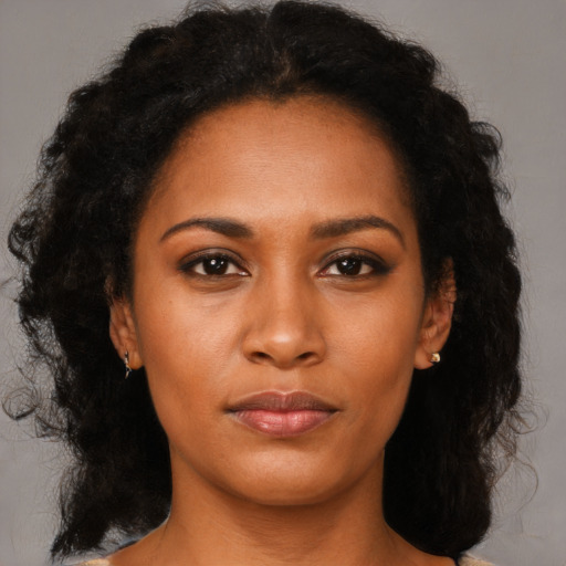 Joyful black young-adult female with long  brown hair and brown eyes