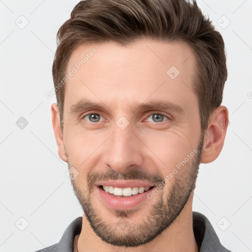 Joyful white young-adult male with short  brown hair and grey eyes